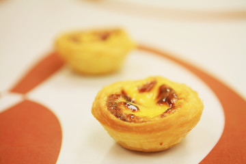 two egg tarts of various flavors on a table..