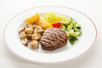 Grilled steaks with chips and vegetables