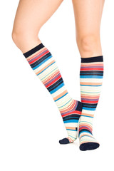Caucasian woman legs in colorful stripped socks on white isolate