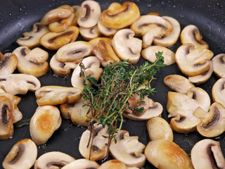 cooking champignon in a black pan