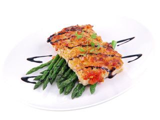 baked fish with green asparagus on white background