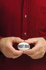 NEST EGG written on egg held by man
