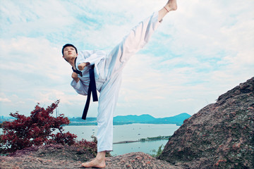 one asian man playing with taekwondo outdoor