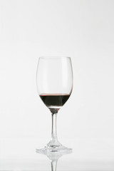 Red wine in wineglass isolated on white background ..
