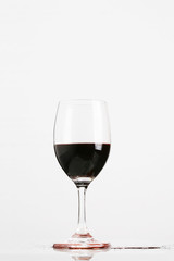 Red wine in wineglass isolated on white background ..