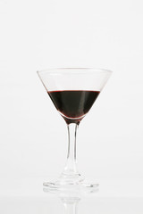 Red wine in wineglass isolated on white background ..