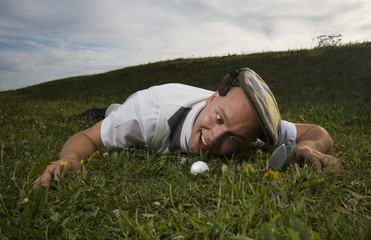 Crazy golfer gazing at golf ball in the rough
