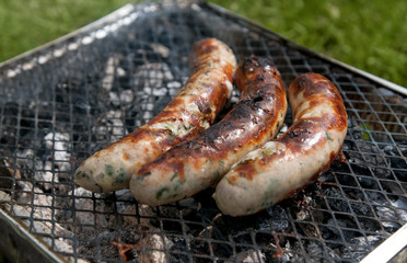 Burnt sausages on picnic grill