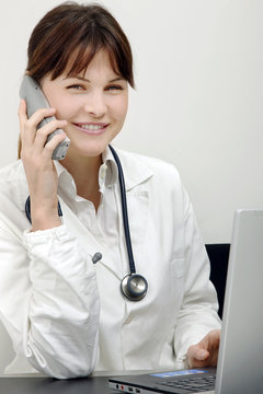 young caucasian woman doctor on the phone with laptop