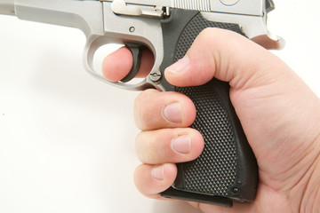 Side view of person holding gun with finger on trigger