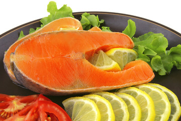 two salmon steak on dark dish