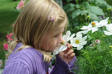 Mädchen riecht an Blumen
