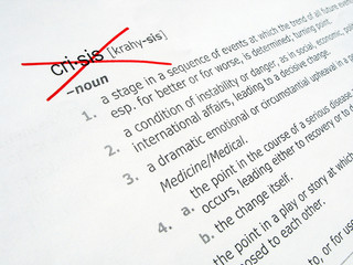 Striked out CRISIS word on a page of a dictionary