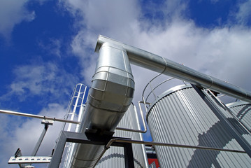 industrial piping and tanks against blue sky