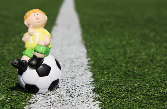 Fu&szlig;ballspielerfigur auf Kunstrasen & Linie, links