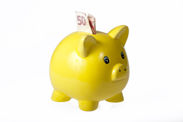 Yellow ceramic piggy bank with one bank note