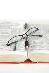 dictionary & pen with glasses