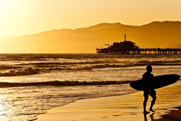 Surfer on Santa Monica Beach at sunset - obrazy, fototapety, plakaty