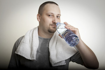 sweaty man drinking water after exercise