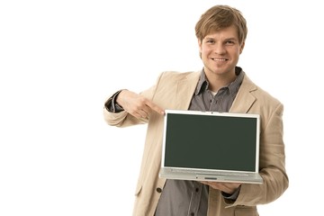 Young man holding laptop with blank screen