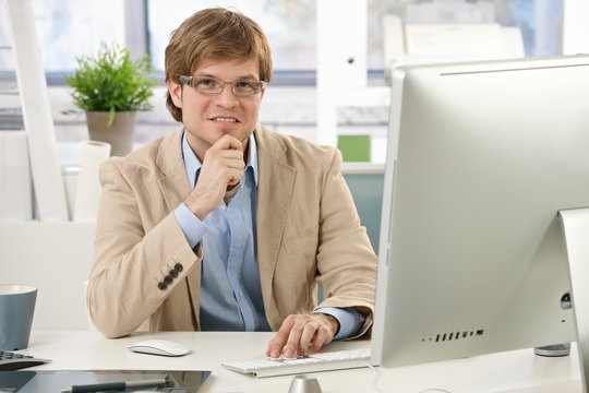 Young businessman thinking at desk
