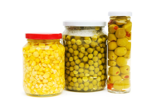 Various pickles in the glass jars on white