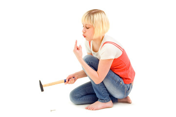 The girl hammers itself hammers in a nail