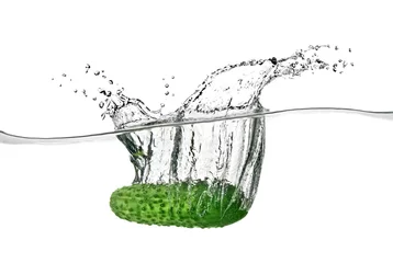 Keuken spatwand met foto Groene komkommer viel in water geïsoleerd op wit © artjazz