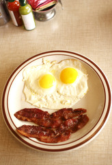 breakfast consisting of eggs sunnyside up and bacon