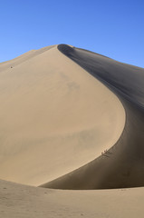 Climbing a sand dune. China