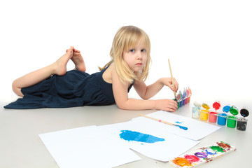 Little girl draws a colored paint