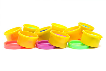 Rows of containers with colorful plasticine on a white backgroun