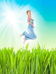Obraz na płótnie Canvas cheerful woman jumping at the green field