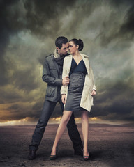 Handsome couple posing over stormy background