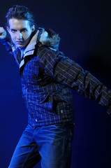 Hip-hop style dancer posing on blue light studio