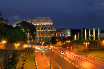 Fototapeta na wymiar Znani rzymskiego Koloseum i oświetlony ulicach Rzymu w nocy.
