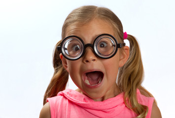 Little girl wearing big round glasses makes a silly expression