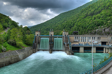 hydroelectric power-plant dam on a river with water overflowing the dam after heavy rain - 22642819