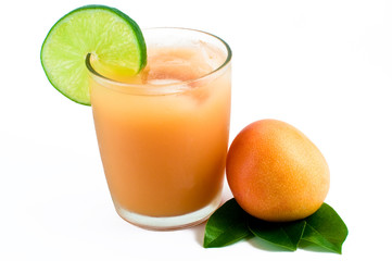 Mango fruit next to a freshly squeezed tropical juice
