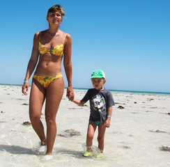 Mum and the son walk on a coast
