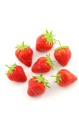 sept fraises sur fond blanc