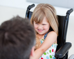 Reserved little girl sitting on the wheelchair