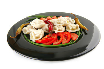 dumplings served with vegetables on black