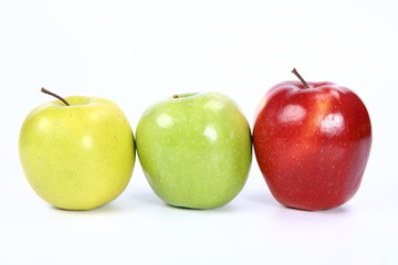 Three apples (green, yellow,red) in a raw on white background