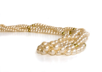 Triple strand simulated pearl necklace on a silver background