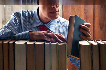 men put a book on to the bookshelf