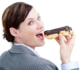 Glowing businesswoman eating a chocolate eclair