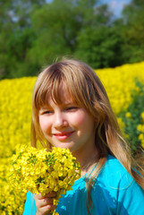 Young girl in spring yellow rape field 