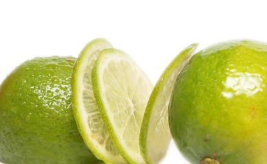 Lime fruit, 2 whole and one in slices towards white