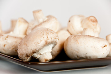 White mushrooms on a brown plate